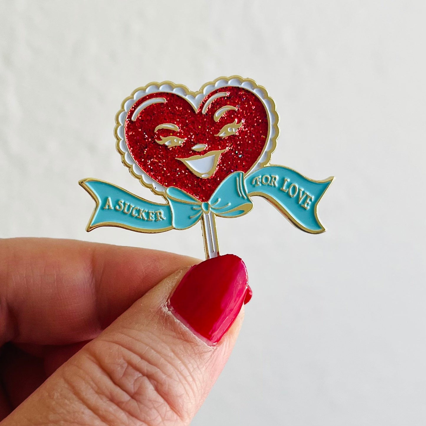 A Sucker For Love soft enamel pin with red glitter